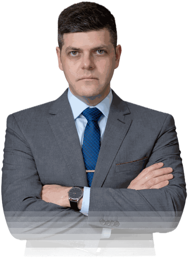 Advogado Anderson Carvalho de braços cruzados, de terno cinza e gravata azul
